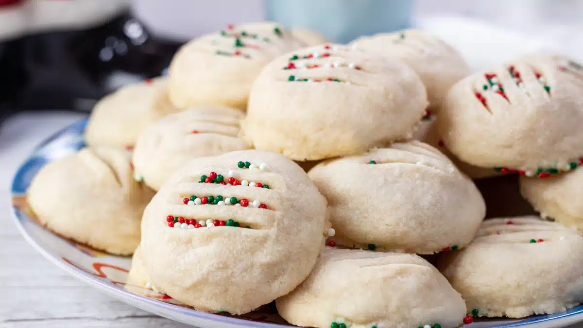 Wide image of whipped shortbread cookies on a blue plate.