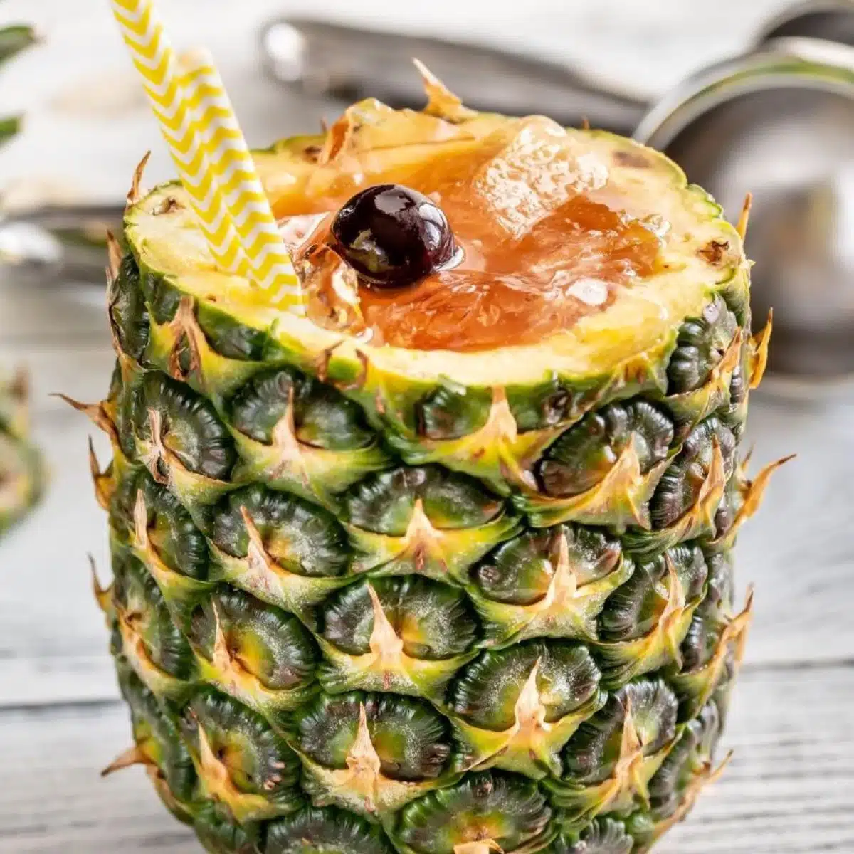 Firkantet billede af en Bahama Mama-cocktail i en opskåret ananas.