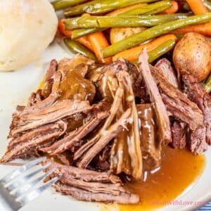 Square image showing slow cooker London broil on a dinner plate.