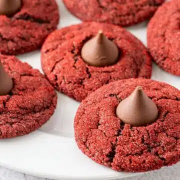 Best red velvet blossom cookies stacked and served on a white plate for sharing.