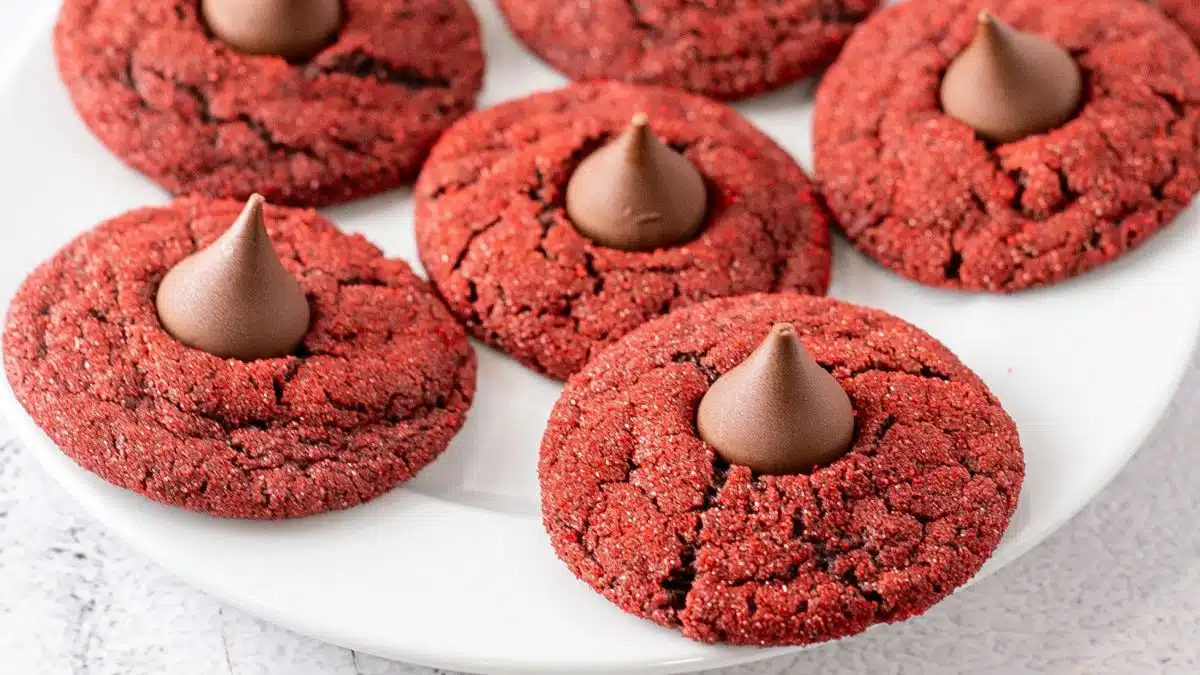 Best red velvet blossom cookies stacked and served on a white plate for sharing.