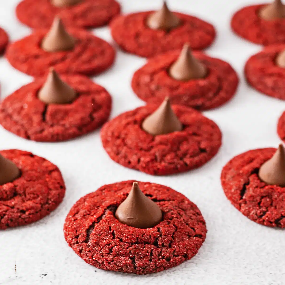 Os melhores biscoitos de veludo vermelho com açúcar vermelho e cobertos com bombons de chocolate Hershey's Kisses.