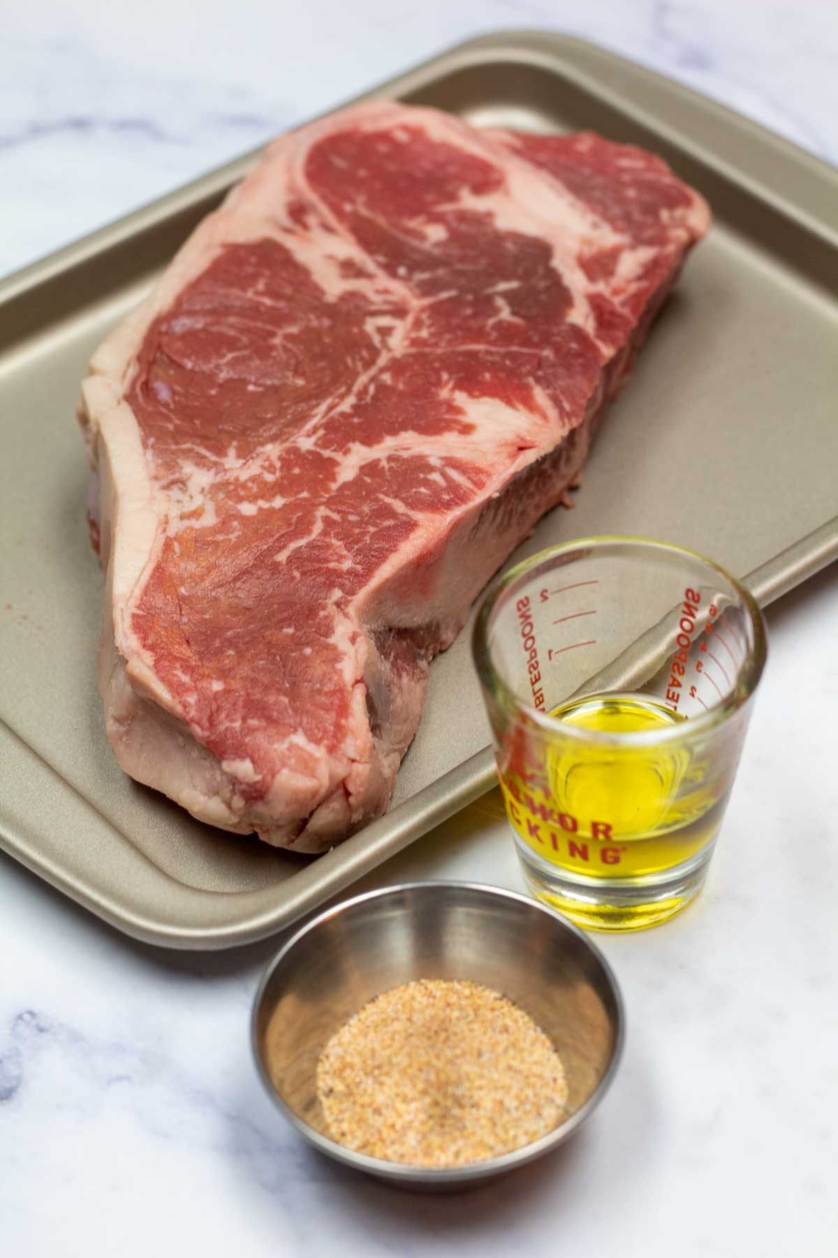 Ingredients needed for a baked NY strip steak.
