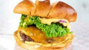 Wide image of a burger with burger sauce.