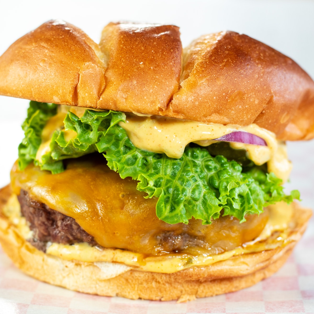 Square image of a burger with burger sauce.