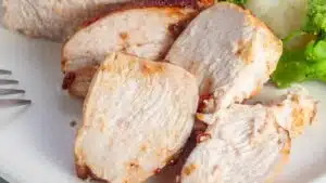 Wide image of sliced chicken breast on a plate.