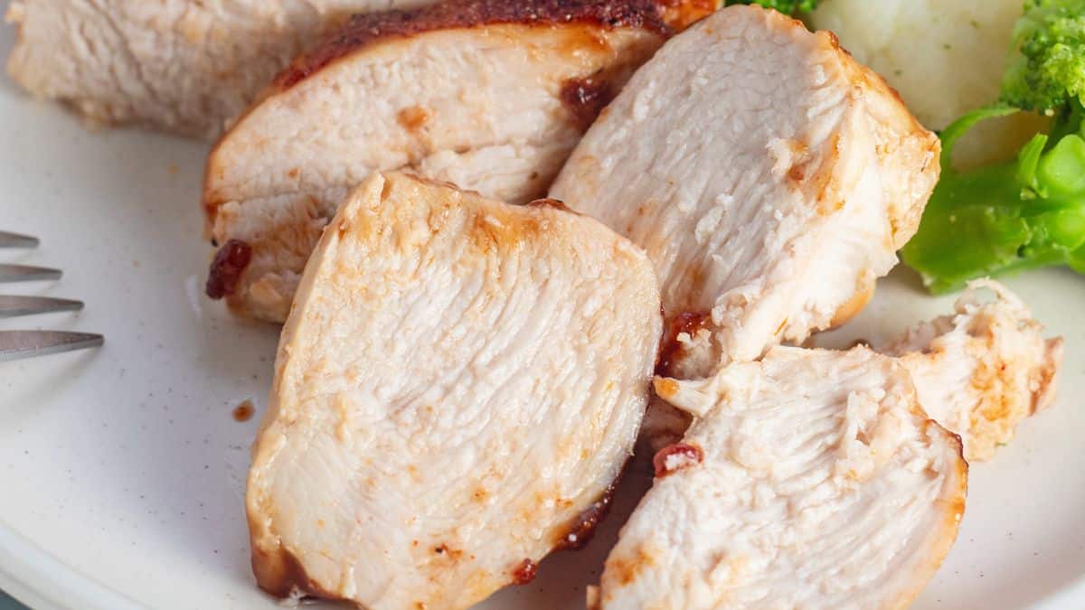 Wide image of sliced chicken breast on a plate.