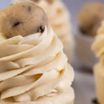 Wide image showing a cupcake with cookie dough buttercream frosting.