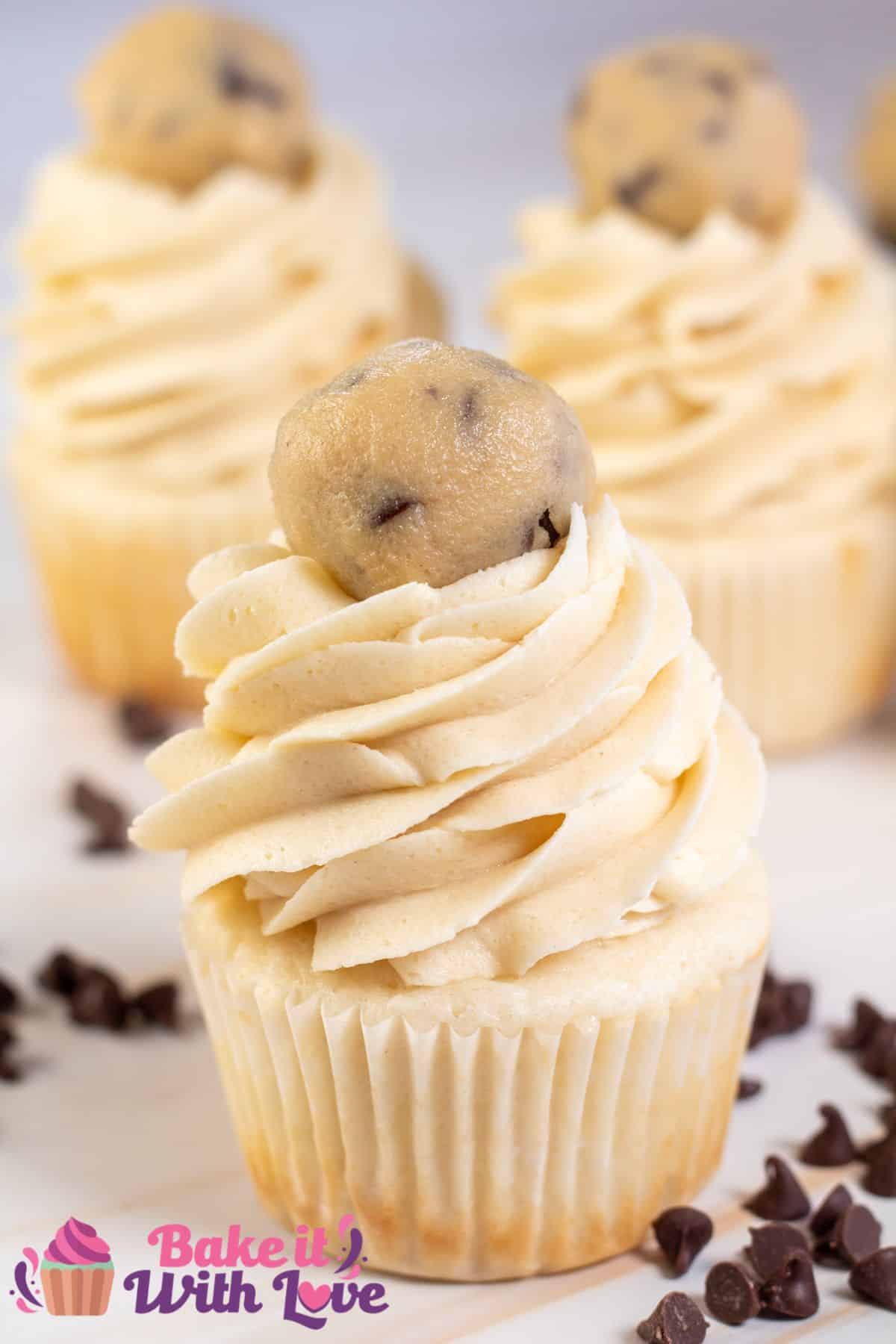 Tall image showing a cupcake with cookie dough buttercream frosting.