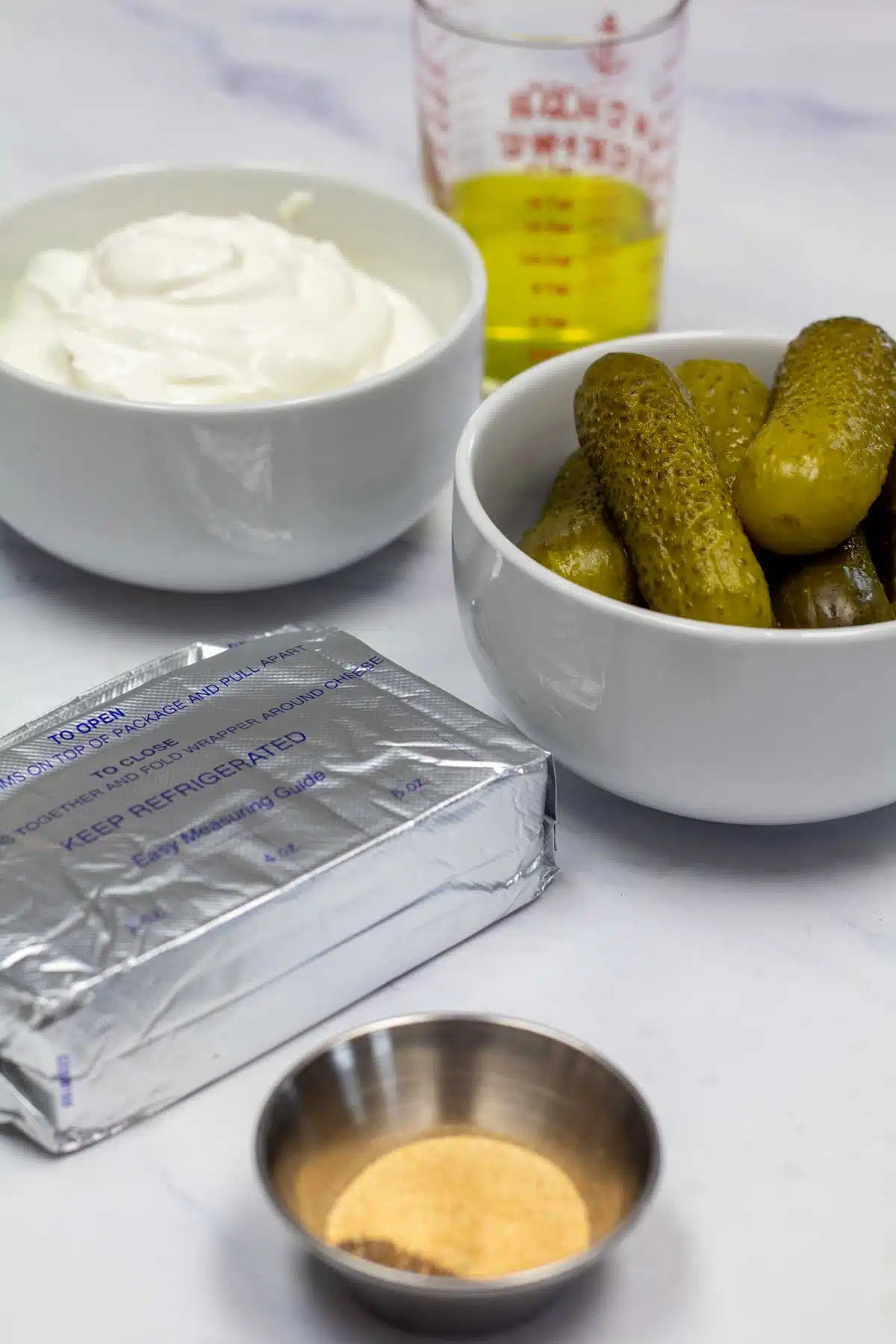 Tall image showing ingredients needed for dill pickle dip.