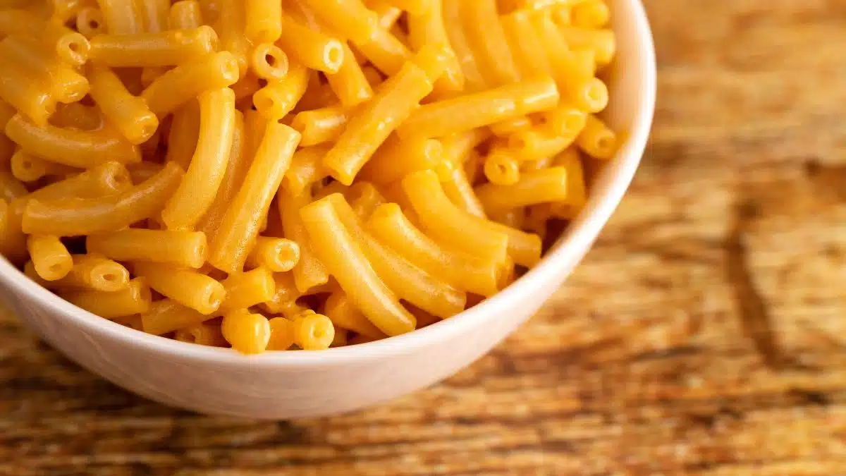 Wide image of cooked boxed mac & cheese in a white bowl.