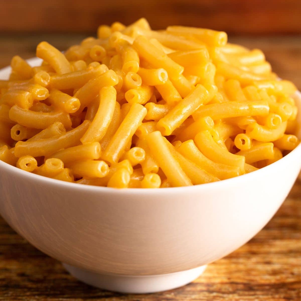 Square image of cooked boxed mac & cheese in a white bowl.