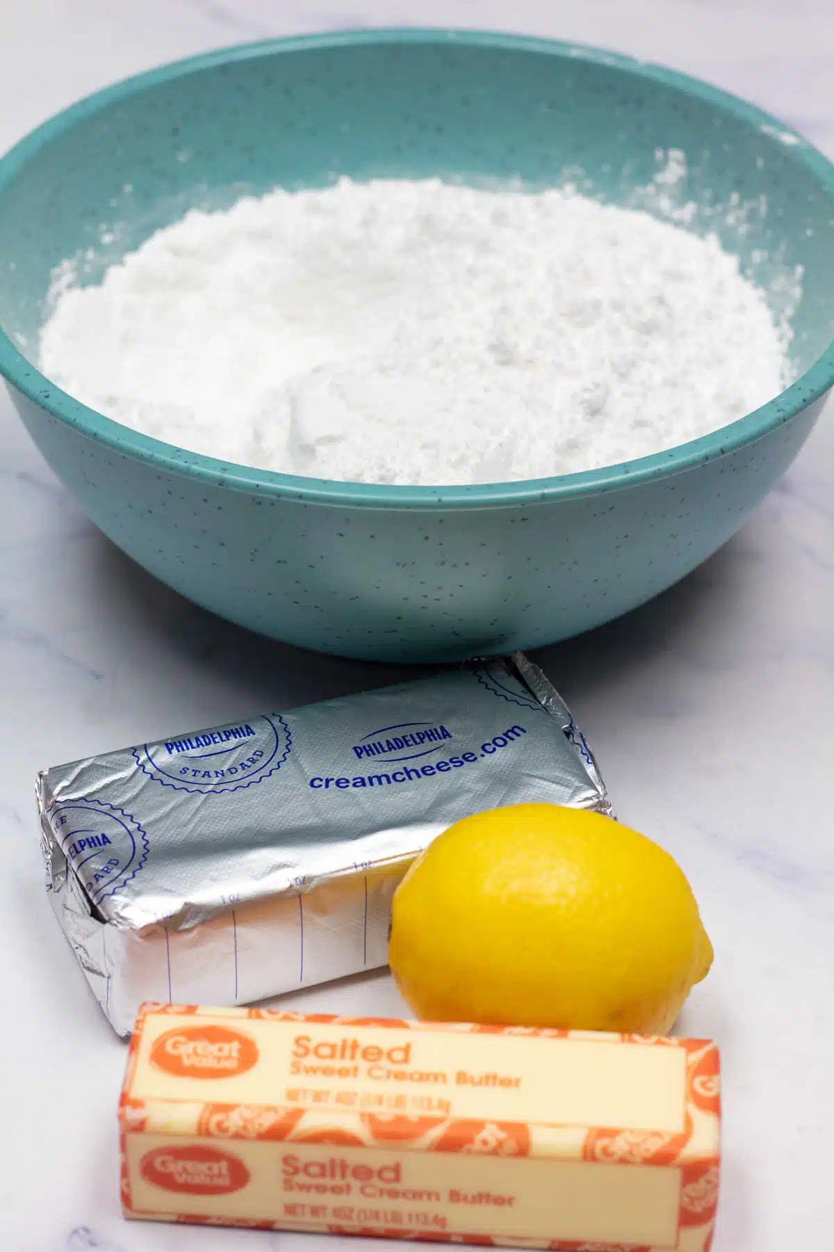 Tall image showing lemon cream cheese frosting ingredients.