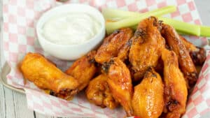 Wide image showing mild buffalo sauce on chicken wings.