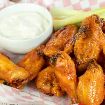 Wide image showing mild buffalo sauce on chicken wings.
