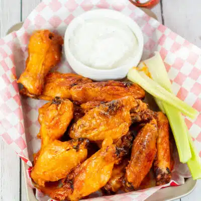 Square image showing mild buffalo sauce on chicken wings.