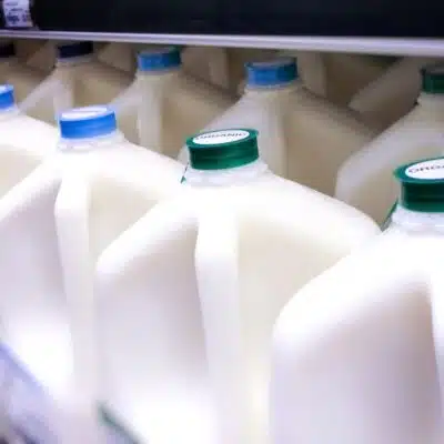 Square image showing milk gallons.