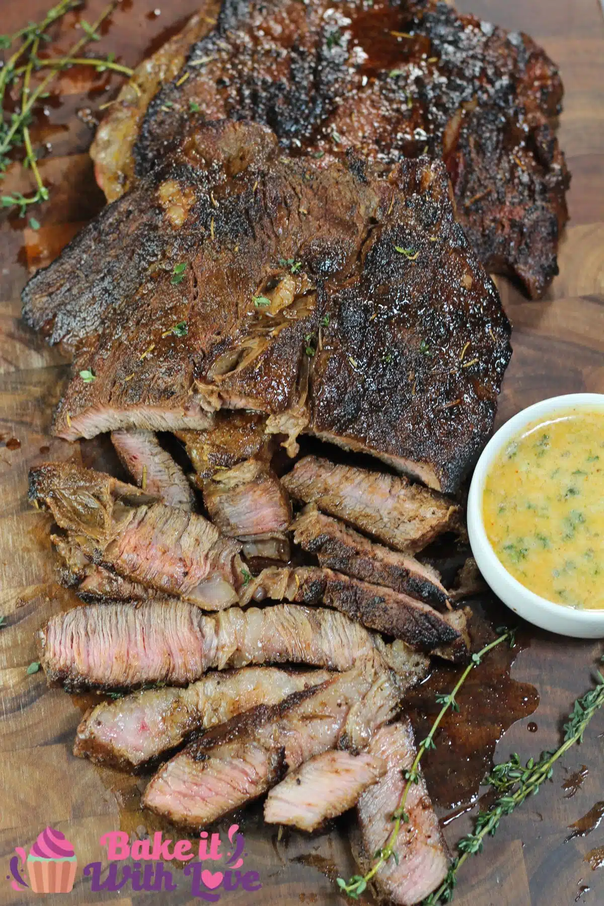Tall image of pan seared chuck steak sliced on a cutting board.