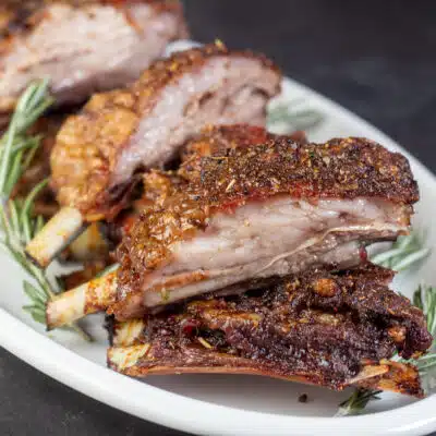 Square image showing lamb breast ribs on a serving plate.