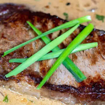 Wide image of steak diane in a pan.