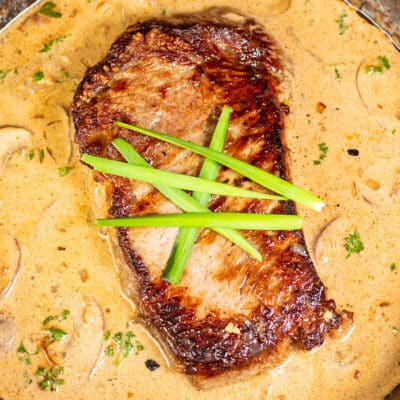 Square image of steak diane in a pan.