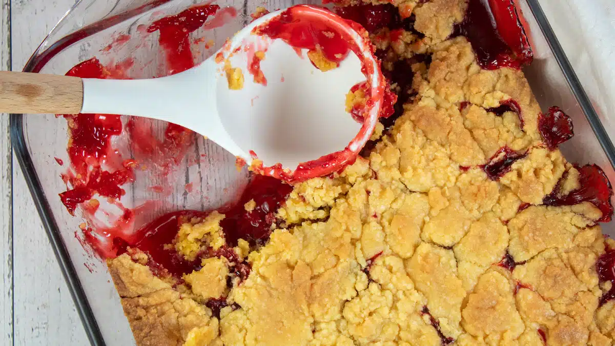 Wide image showing strawberry dump cake in a 9x13 glass baking dish.