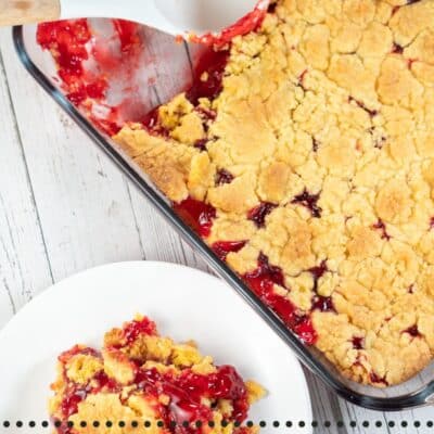 Pin image with text showing strawberry dump cake in a 9x13 glass baking dish and a serving on a plate.