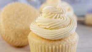 Wide image showing vanilla buttercream frosting on a cupcake.
