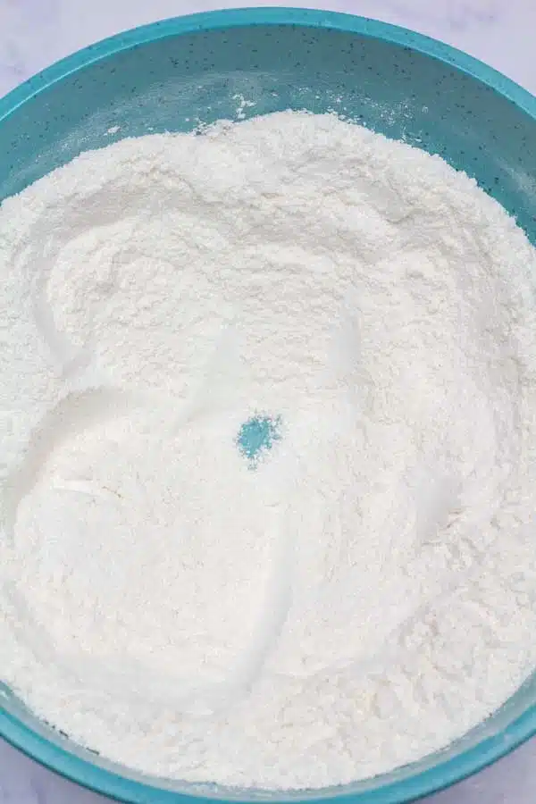 Process image 3 showing combined dry ingredients in a mixing bowl with a well in the center.