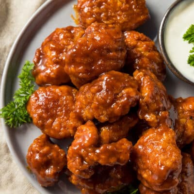 Square image of boneless chicken wings on a plate.