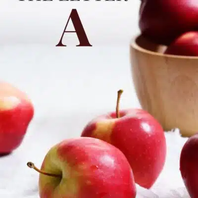 Fruits that start with A pin featuring a wooden bowl filled with apples.