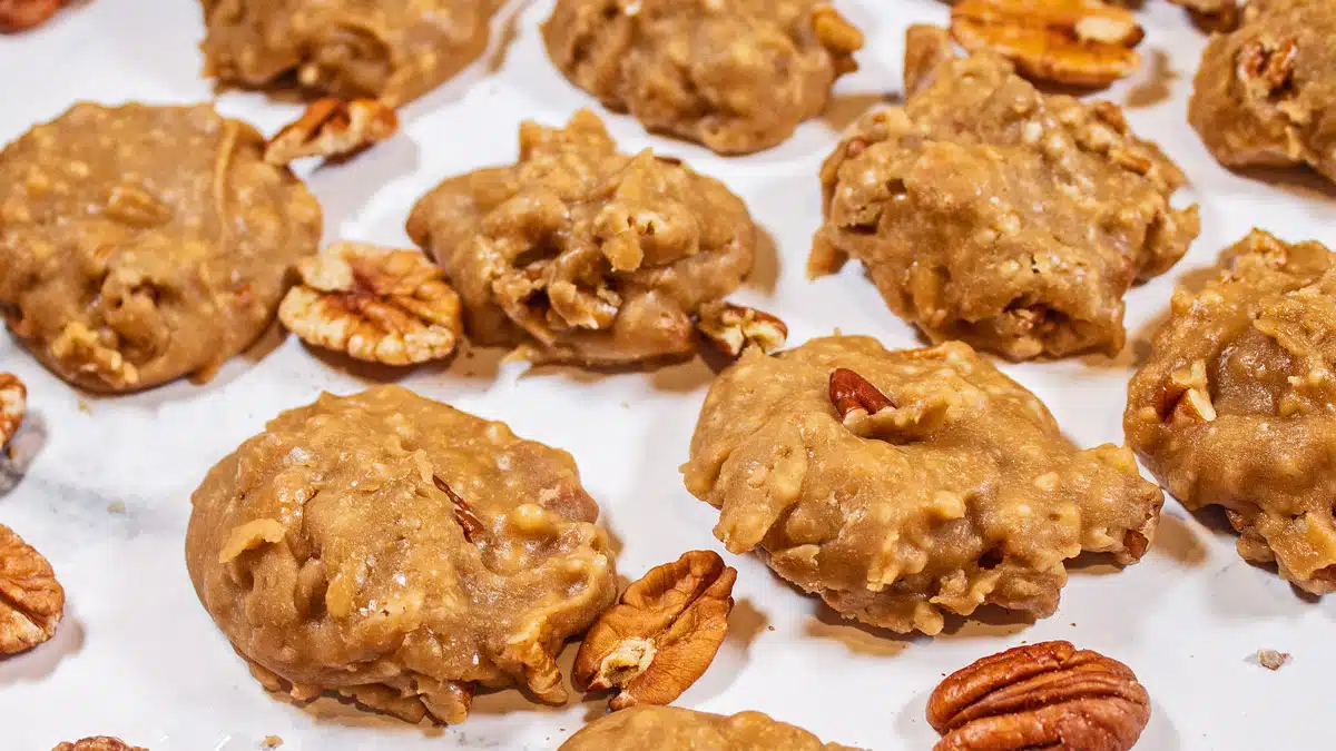 Mexican pralines no-bake candy on light background with scattered pecans.