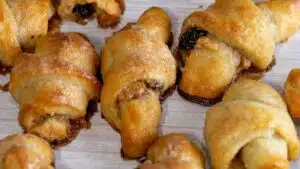 Delicious golden rugelach in a single layer on light background.
