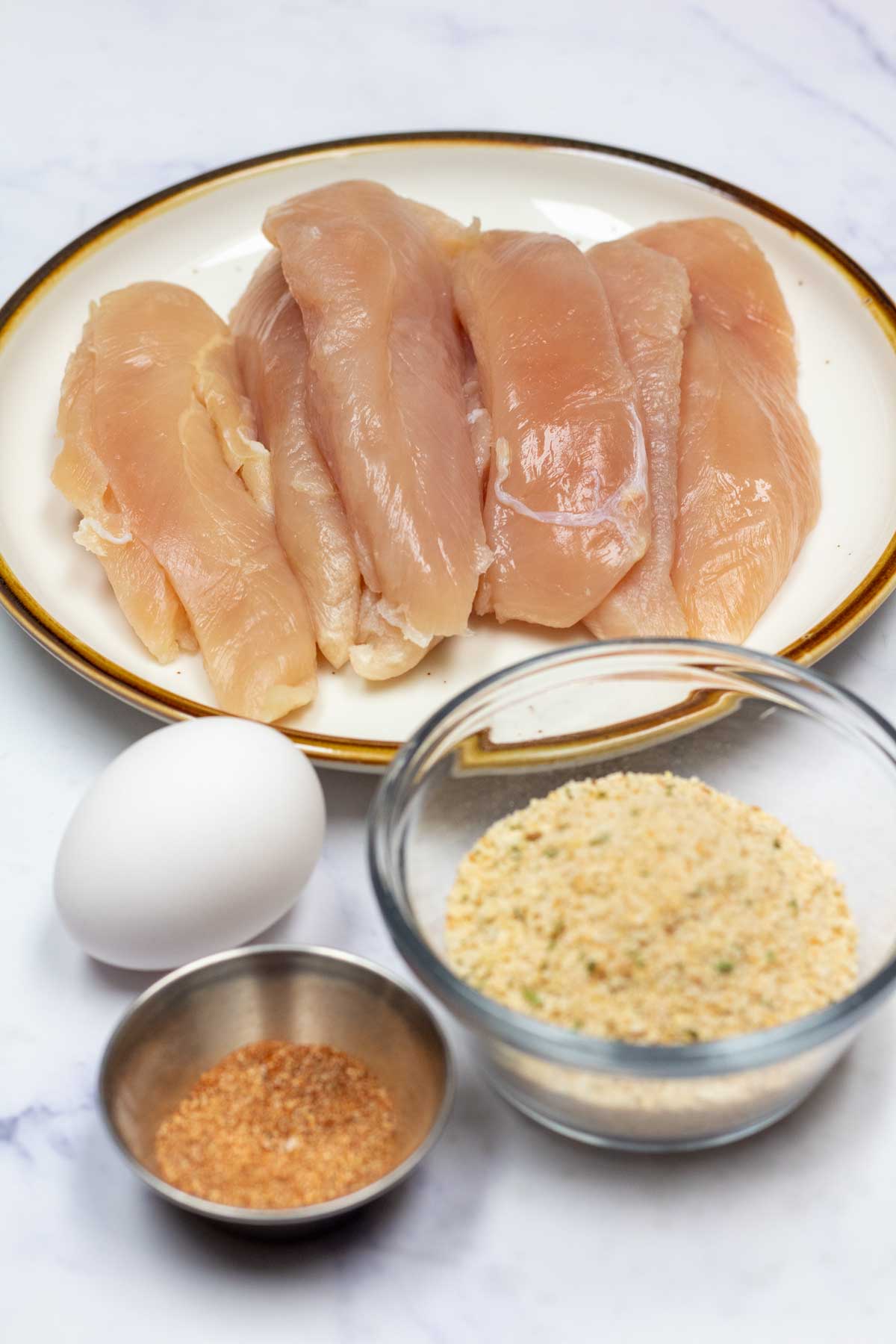 Tall image showing ingredients needed for air fryer chicken tenderloins.