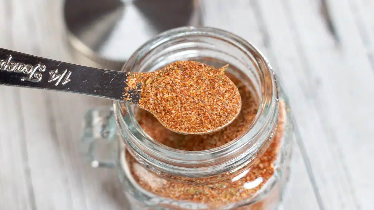 Wide image of a glass jar filled with homemade all purpose seasoning.