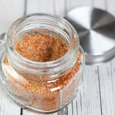 Square image of a glass jar filled with homemade all purpose seasoning.