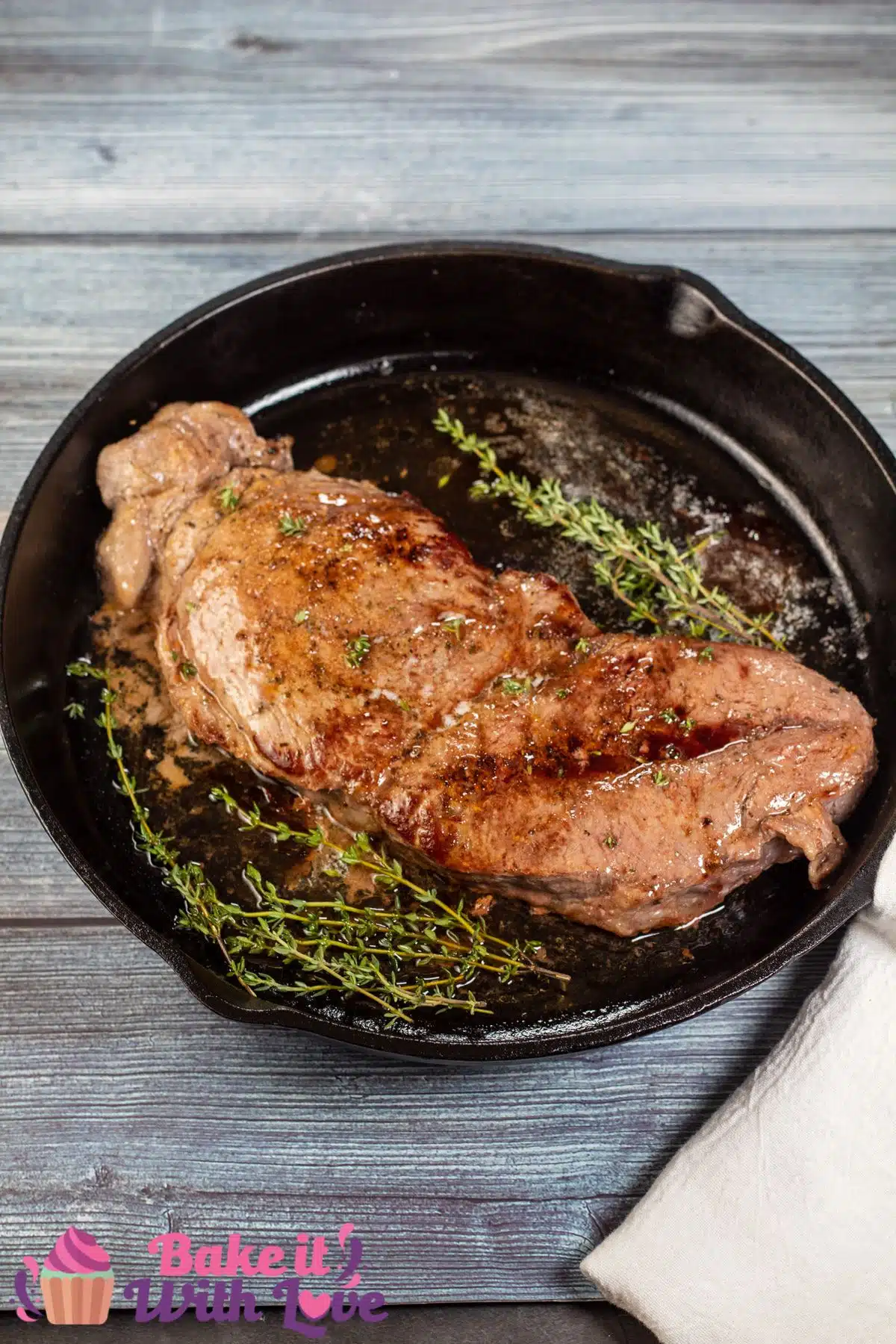 Tall image of baked chuck steak in a cast iron pan.