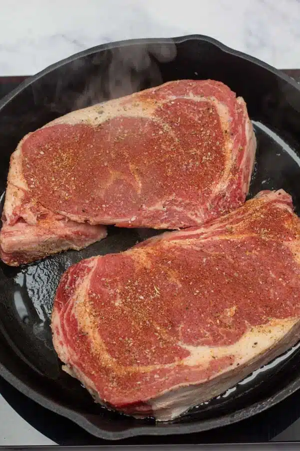 Process image 1 showing searing ribeye steaks.