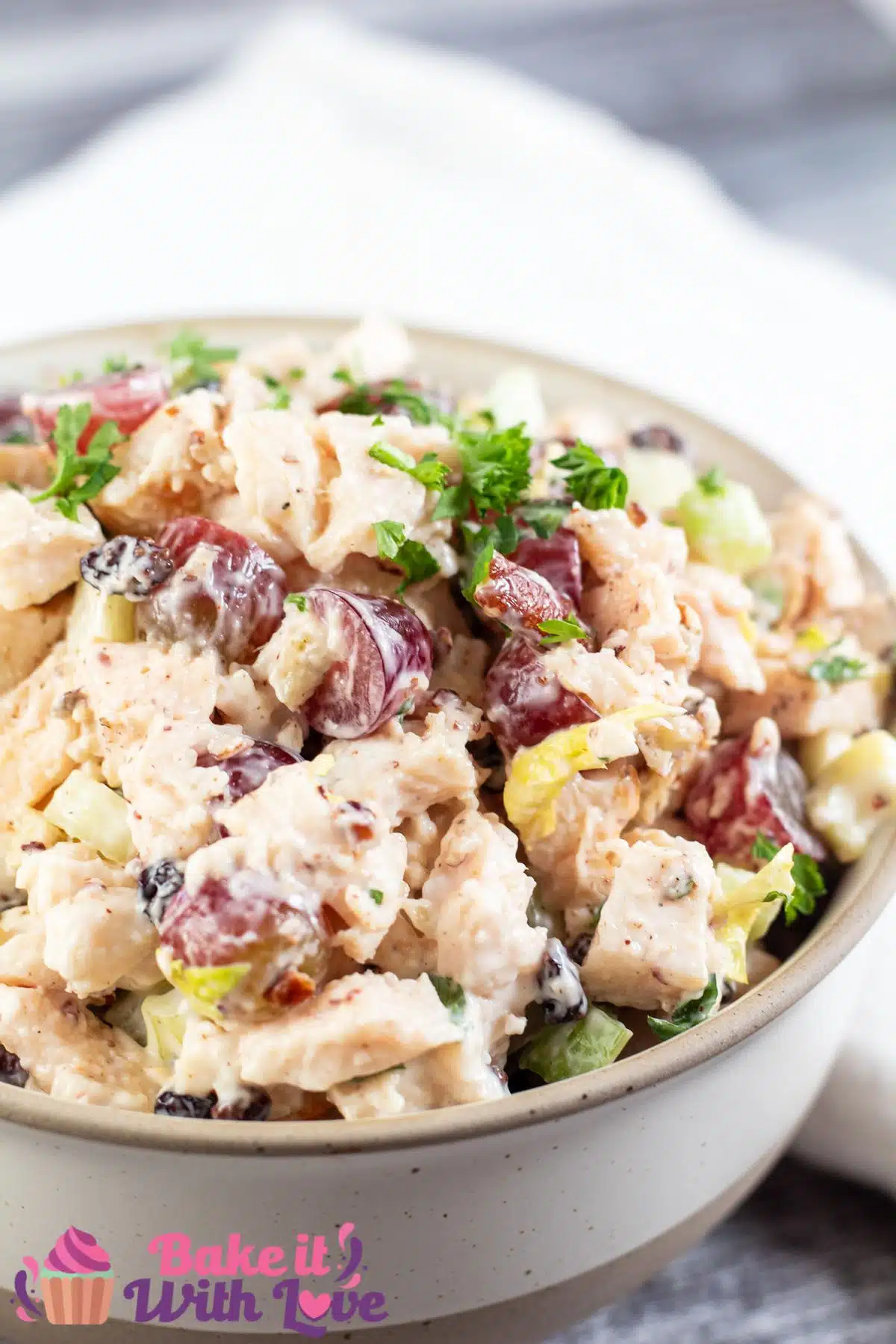 Tall image of a bowl of chicken salad with grapes.