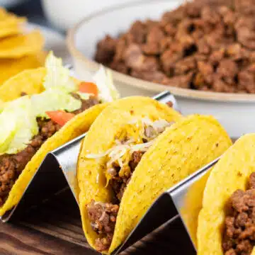 Wide image of a trio of ground beef tacos.