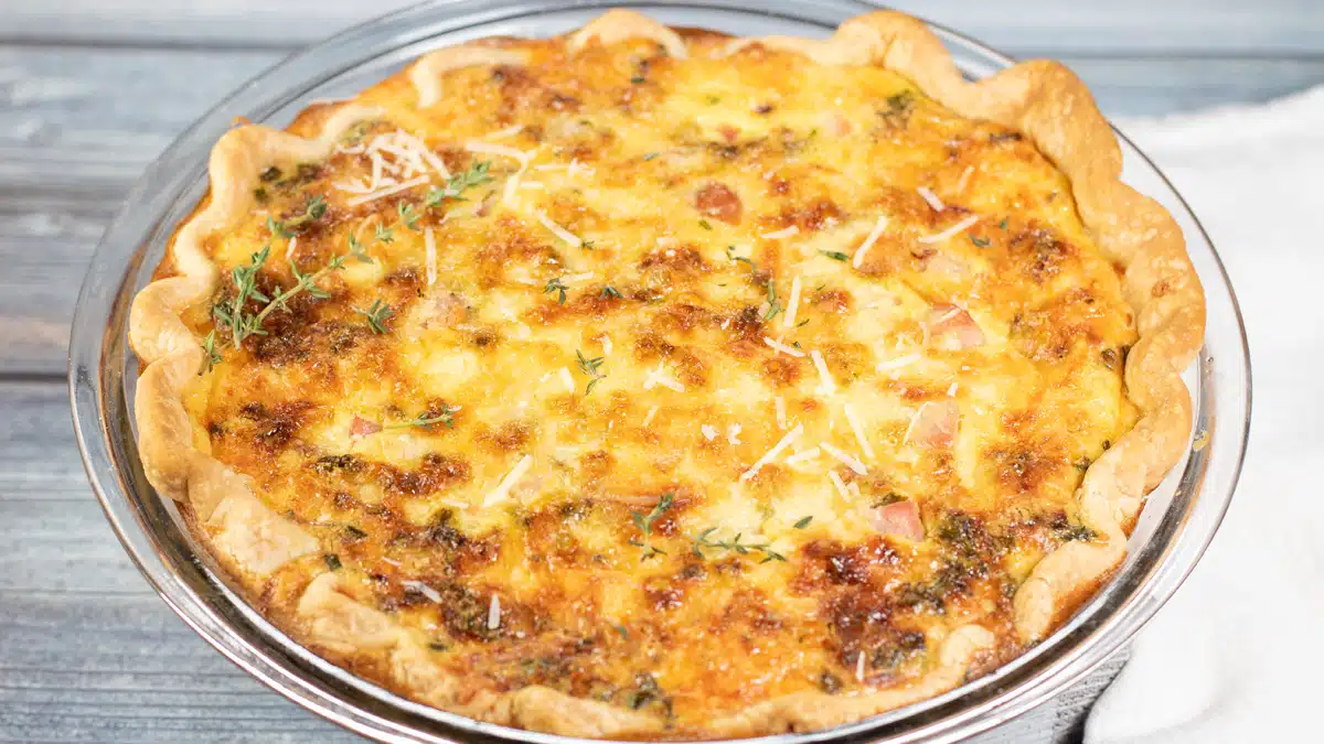 Wide image of a ham and cheese quiche.