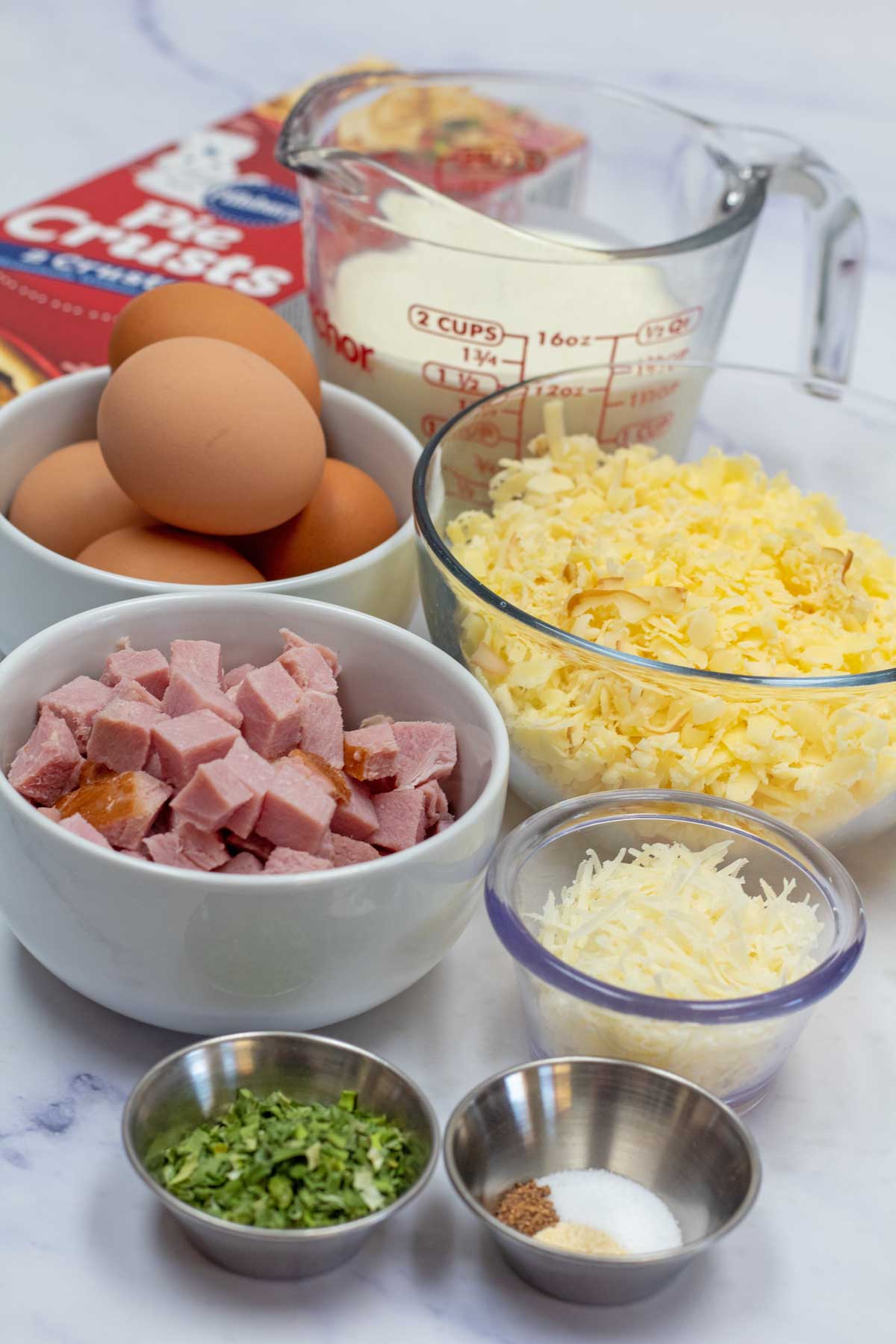 Tall image showing ham and cheese quiche ingredients.