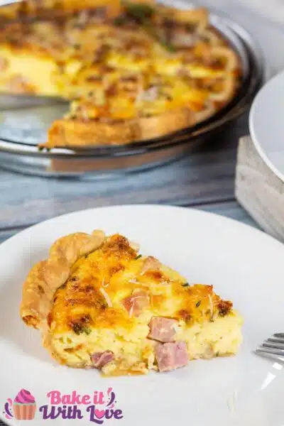 Tall image of a slice of a ham and cheese quiche.