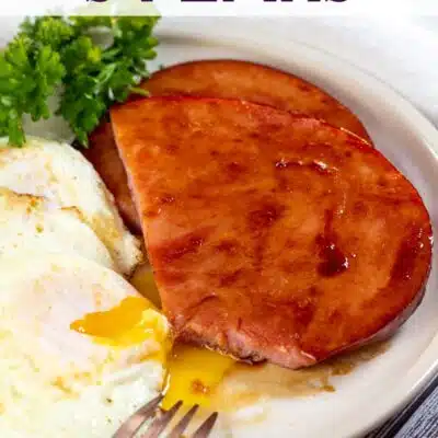 Pin image with text of ham steaks with eggs on a plate.