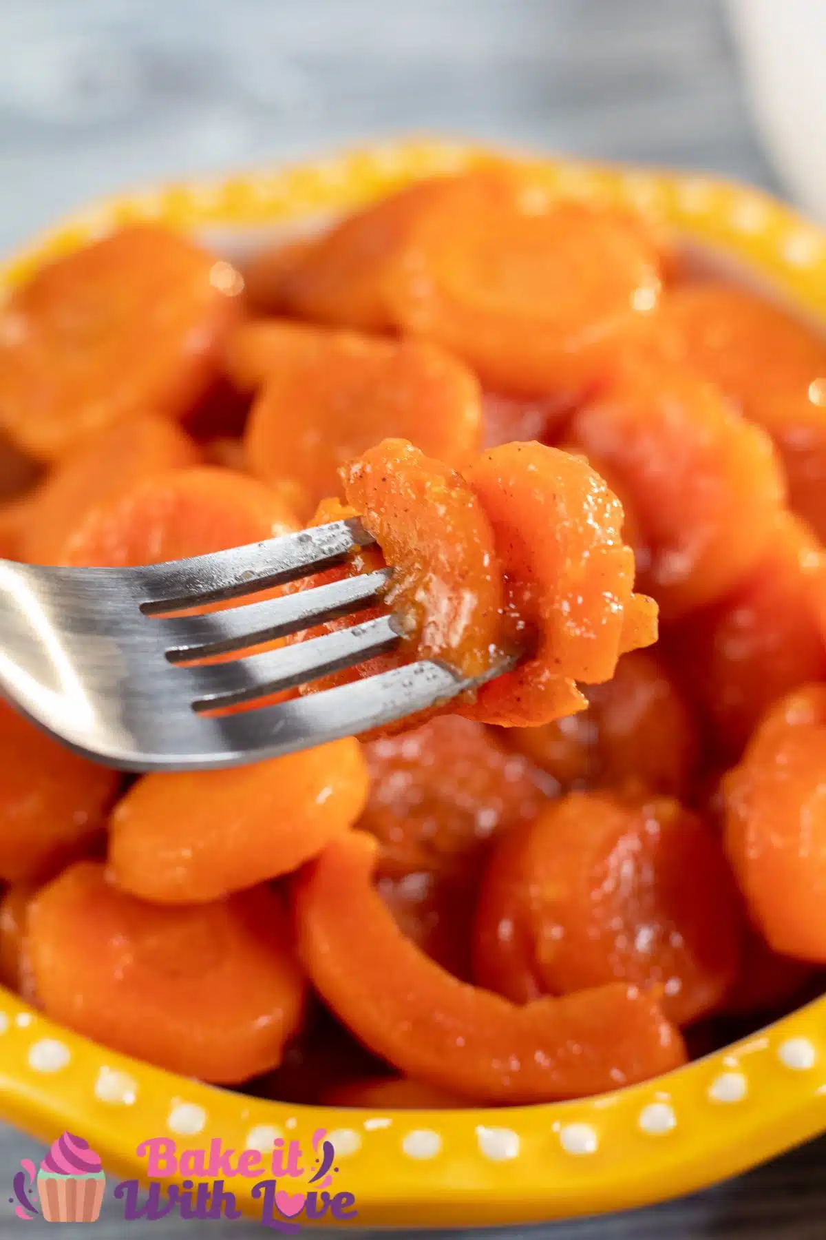 Tall image showing canned cooked carrots in a bowl.