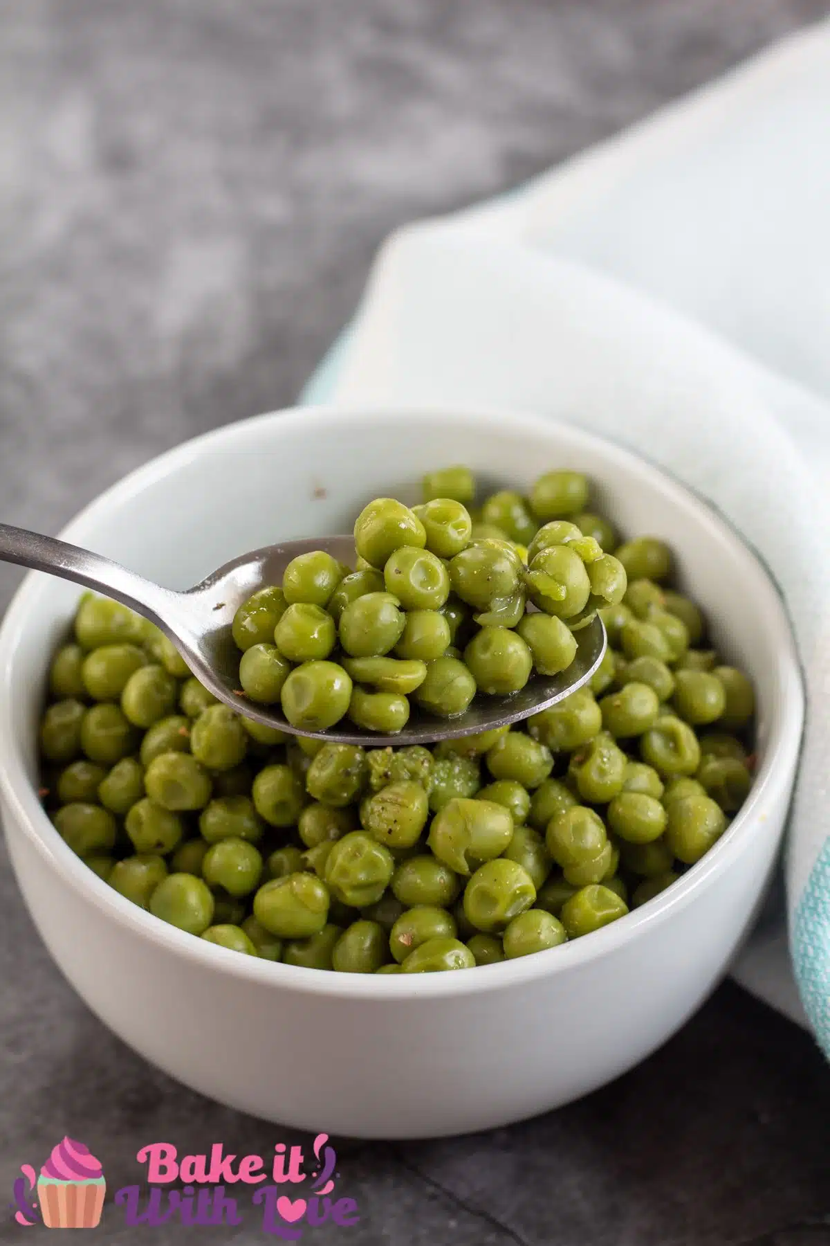 Tall image showing canned cooked peas in a small white bowl.