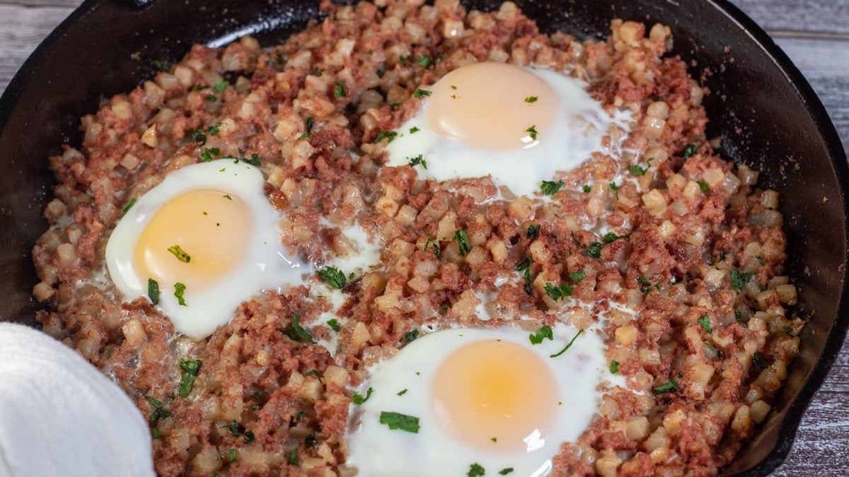 Wide image showing canned corned beef hash and eggs.