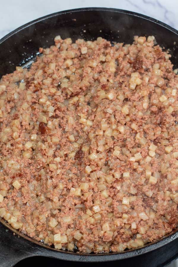 Process image 2 showing canned cooking corned beef hash in skillet.
