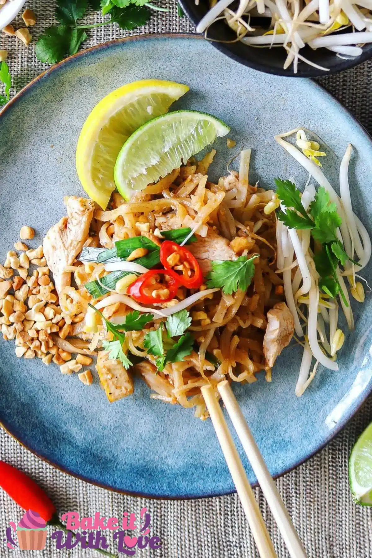 Tall image of pad thai on a blue plate.
