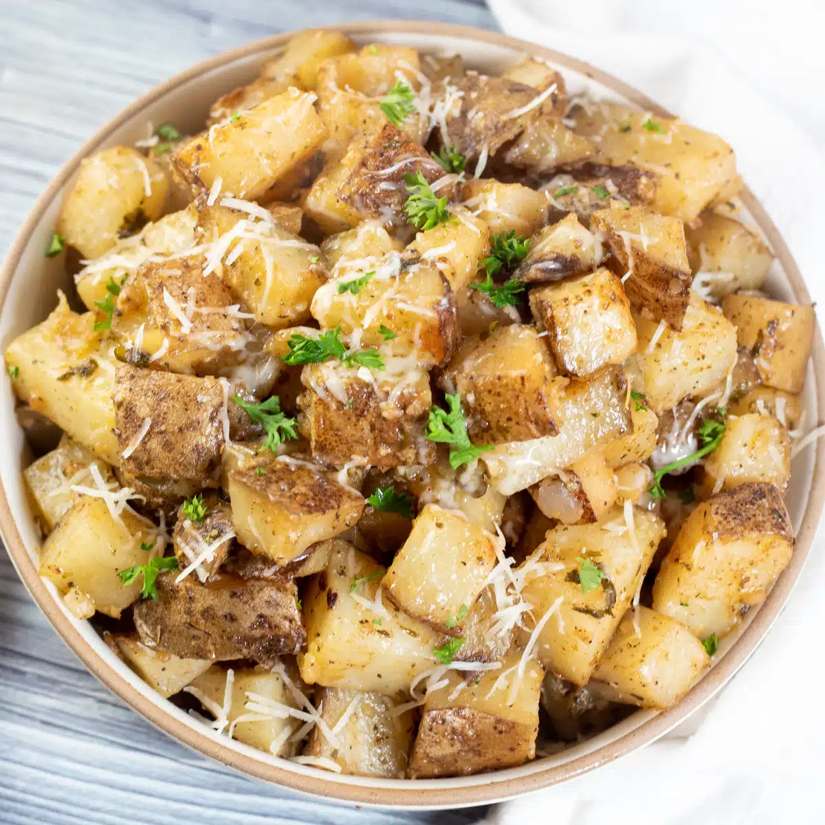 Square image of slow cooker roasted potatoes in a bowl.
